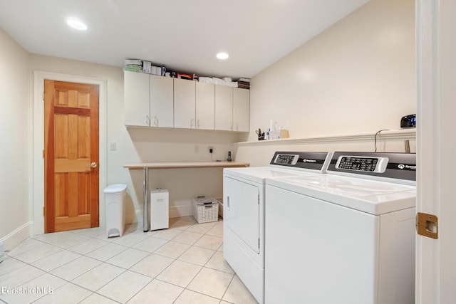 washroom with cabinets, light tile patterned floors, and washing machine and clothes dryer