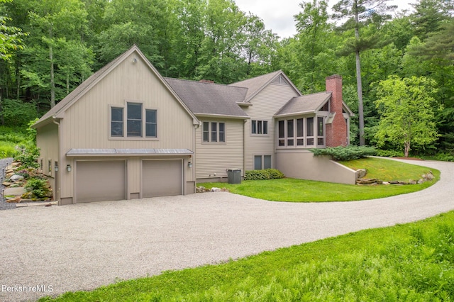 view of front of house featuring central AC unit, a garage, and a front yard