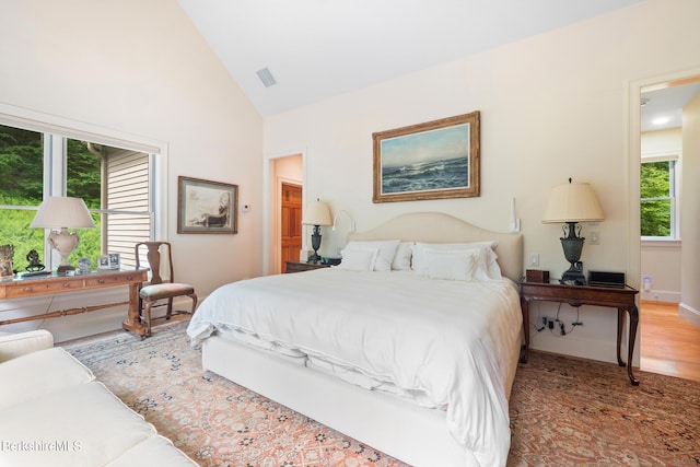 bedroom featuring lofted ceiling and light hardwood / wood-style flooring