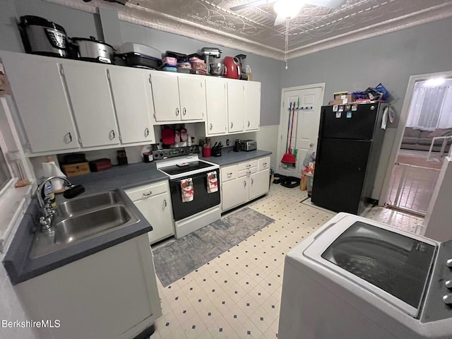 kitchen with white cabinets, sink, black fridge, and electric stove