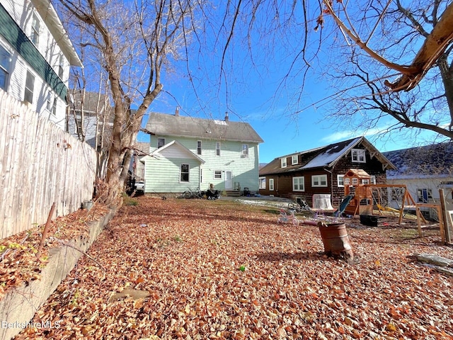 back of house with a playground