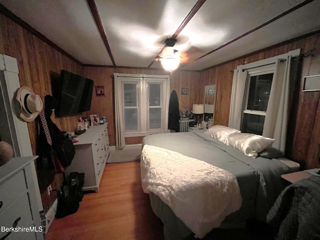 bedroom featuring ceiling fan and wooden walls