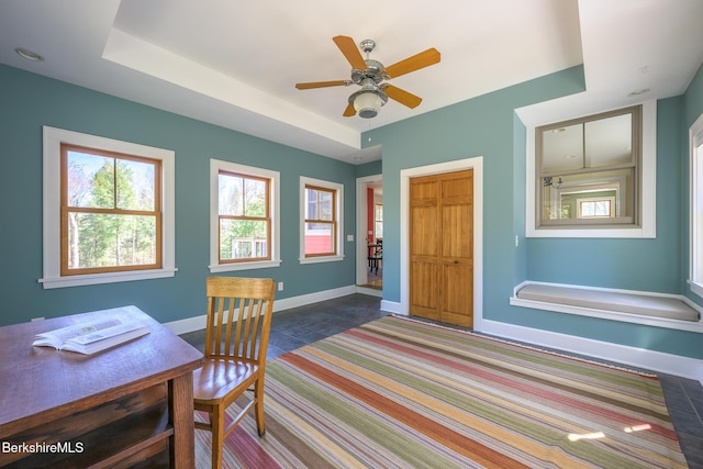 office space featuring baseboards, ceiling fan, and carpet floors