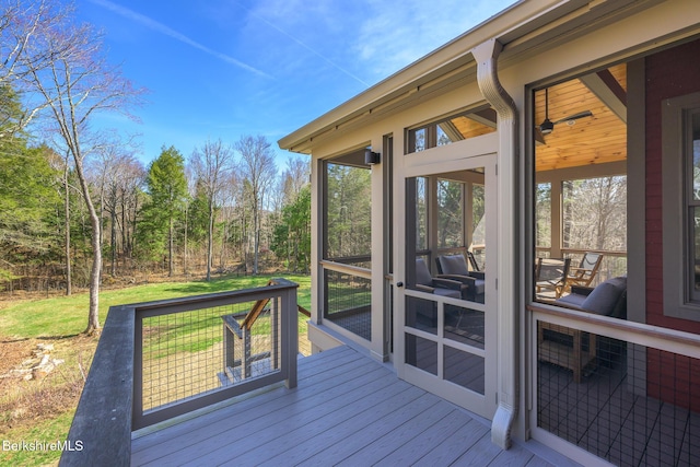 wooden deck featuring a sunroom and a lawn