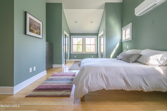bedroom featuring baseboards, recessed lighting, a wall mounted air conditioner, and wood finished floors
