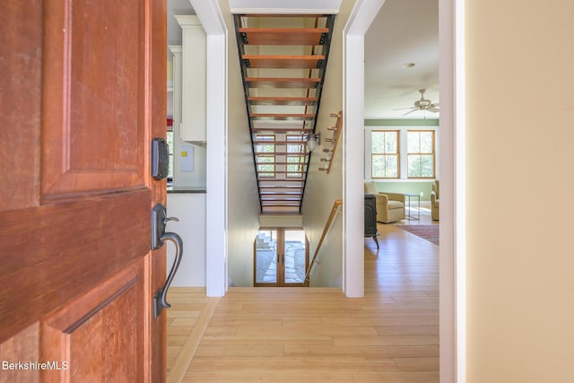 foyer with stairway, ceiling fan, and light wood-type flooring