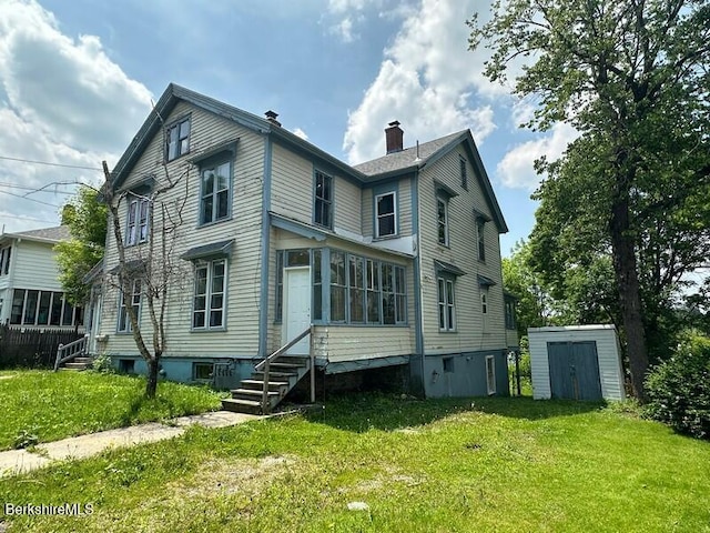 27-29 Daniels Ave, Pittsfield, MA 01201 - back of house with entry steps, a storage unit, a yard, and a chimney