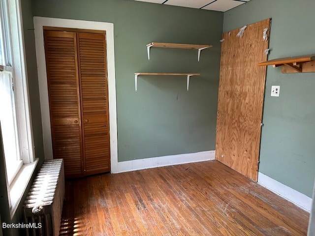 27-29 Daniels Ave, Pittsfield, MA 01201 - unfurnished bedroom with wood finished floors, a closet, and radiator heating unit