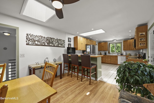 4 Birch Hill Rd, Peru, MA 01235 - kitchen with appliances with stainless steel finishes, a skylight, a peninsula, a kitchen breakfast bar, and ceiling fan