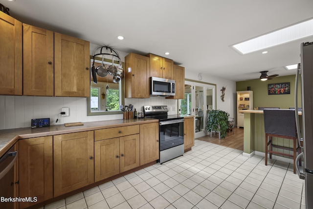 4 Birch Hill Rd, Peru, MA 01235 - kitchen featuring stainless steel appliances, light tile patterned floors, a ceiling fan, brown cabinetry, and recessed lighting