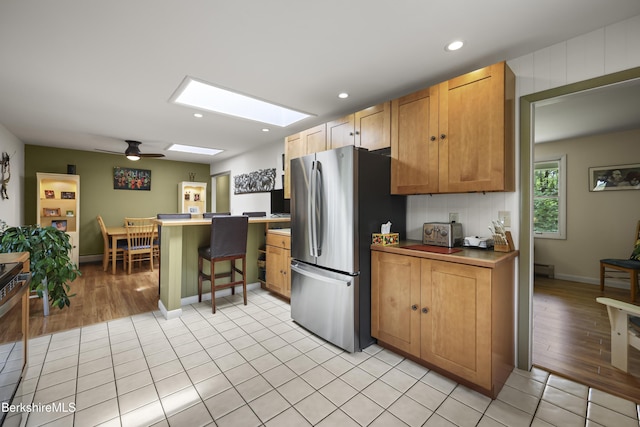 4 Birch Hill Rd, Peru, MA 01235 - kitchen featuring freestanding refrigerator, a skylight, a peninsula, a breakfast bar area, and a ceiling fan