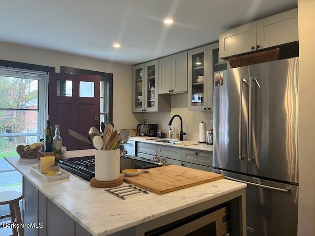 132 Sandisfield Rd, Sandisfield, MA 01255 - kitchen with freestanding refrigerator, a sink, a center island, gray cabinetry, and black cooktop