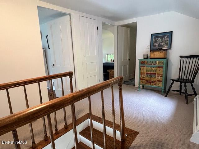 132 Sandisfield Rd, Sandisfield, MA 01255 - hall with arched walkways, carpet floors, an upstairs landing, and lofted ceiling