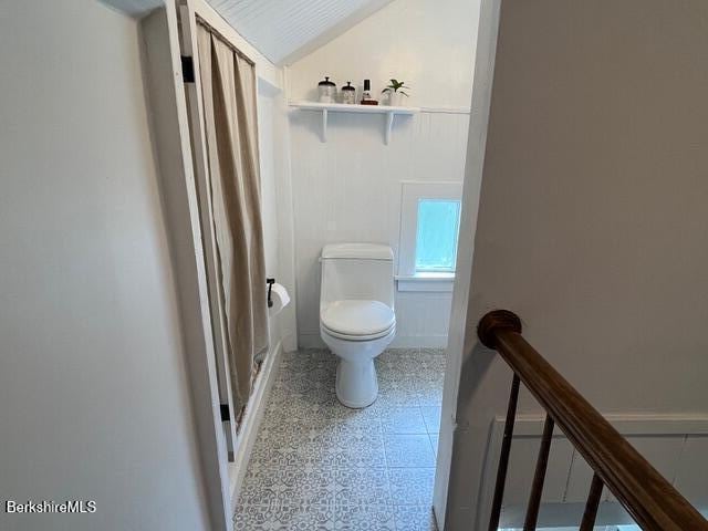 132 Sandisfield Rd, Sandisfield, MA 01255 - bathroom with toilet, curtained shower, wainscoting, lofted ceiling, and a decorative wall