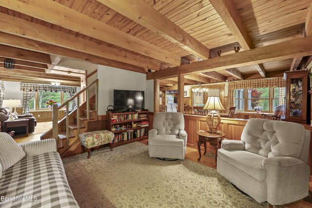 135 E St, Lee, MA 01238 - living room with a chandelier, healthy amount of natural light, stairs, a wood ceiling with exposed beams, and wooden walls