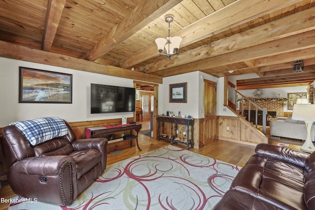 135 E St, Lee, MA 01238 - living area with wood finished floors, a wooden ceiling with exposed beams, a wainscoted wall, a fireplace, and stairs