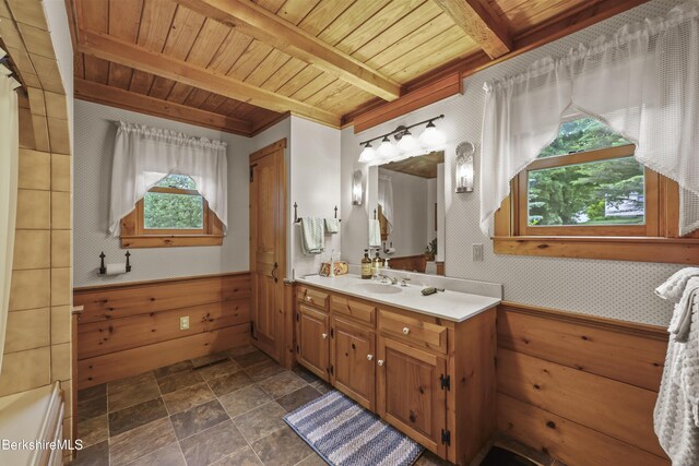 135 E St, Lee, MA 01238 - full bath featuring vanity, a wooden ceiling with exposed beams, stone finish flooring, wainscoting, and a bathtub