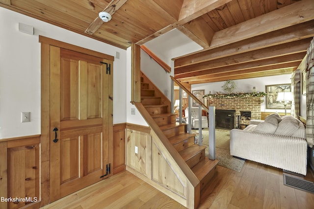 135 E St, Lee, MA 01238 - stairway with wainscoting, a brick fireplace, wood finished floors, wood ceiling, and wood walls