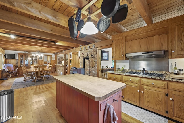 135 E St, Lee, MA 01238 - kitchen featuring under cabinet range hood, light wood finished floors, wood counters, stainless steel gas stovetop, and a chandelier
