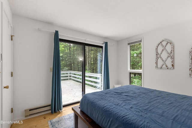 454 Seneca Dr, Becket, MA 01223 - bedroom with wood finished floors, baseboard heating, and access to exterior
