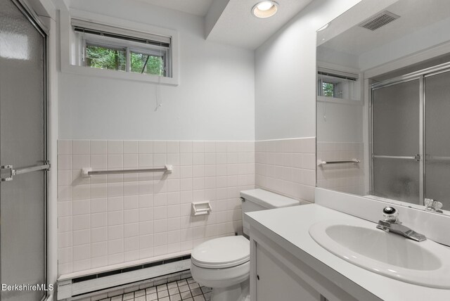454 Seneca Dr, Becket, MA 01223 - bathroom with a baseboard heating unit, tile walls, a shower with shower door, vanity, and tile patterned flooring