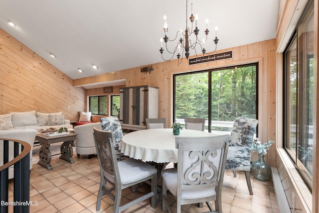 454 Seneca Dr, Becket, MA 01223 - dining area featuring wooden walls, vaulted ceiling, a chandelier, and light tile patterned floors