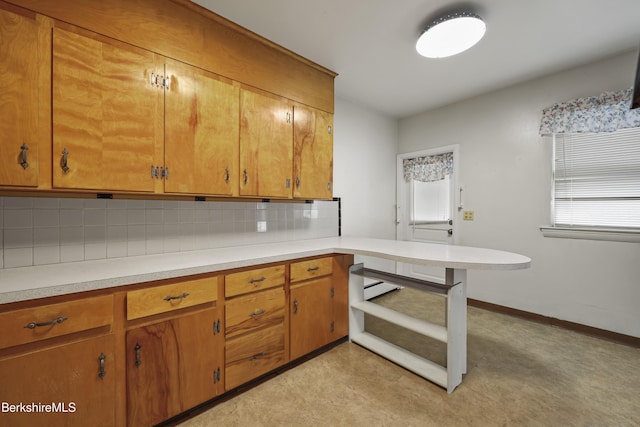 34-36 Crandall St, Adams, MA 01220 - kitchen with light countertops, backsplash, brown cabinetry, and a peninsula