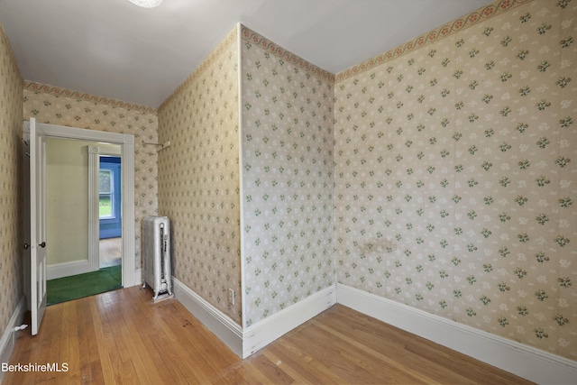 34-36 Crandall St, Adams, MA 01220 - unfurnished room featuring radiator heating unit, wood-type flooring, and wallpapered walls