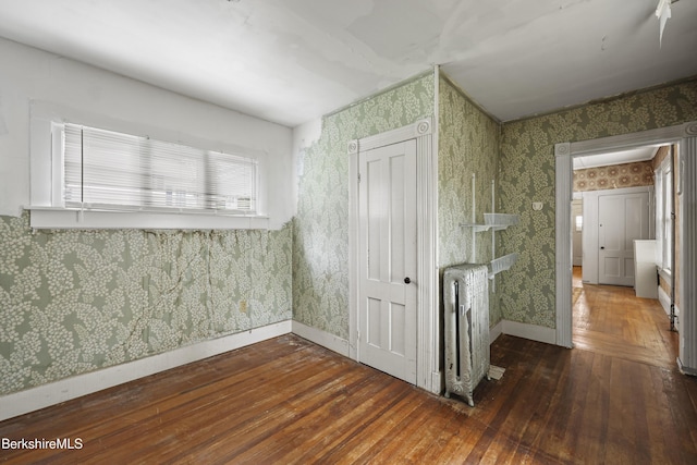 34-36 Crandall St, Adams, MA 01220 - corridor featuring wallpapered walls, radiator heating unit, and hardwood / wood-style flooring
