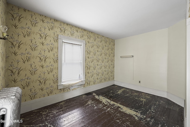 34-36 Crandall St, Adams, MA 01220 - empty room with wallpapered walls, radiator heating unit, and wood-type flooring