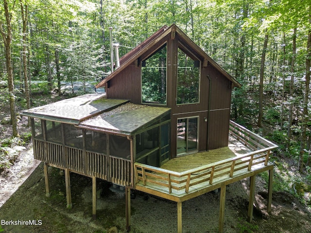 back of property with a sunroom and a deck