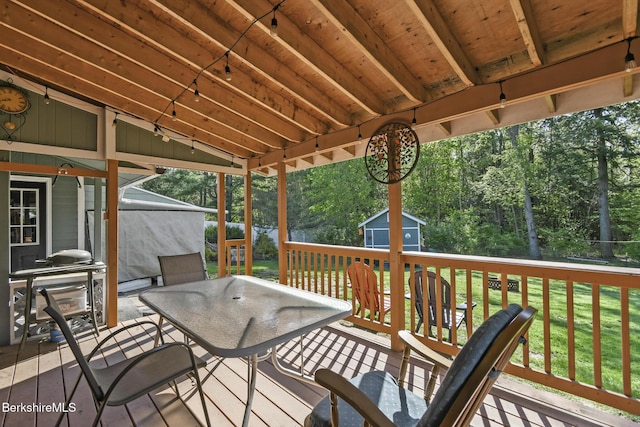 110 Maple Grove Dr, Pittsfield, MA 01201 - wooden terrace featuring outdoor dining area, a storage unit, an outdoor structure, a yard, and view of wooded area