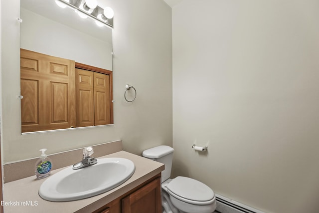 bathroom featuring vanity, toilet, and a baseboard heating unit