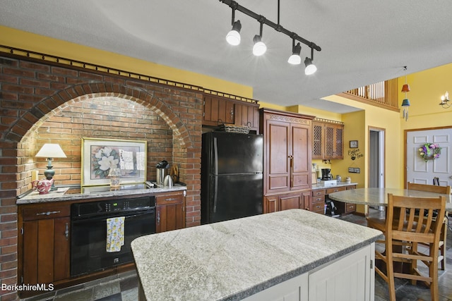 131 Wilshire Dr, Cheshire, MA 01225 - kitchen featuring black appliances, a kitchen island, brick wall, and a textured ceiling