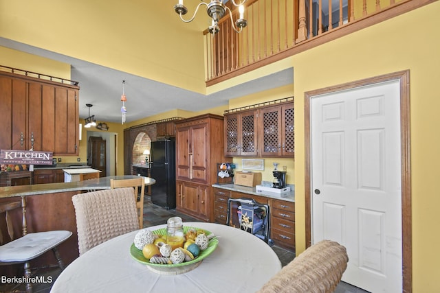 131 Wilshire Dr, Cheshire, MA 01225 - kitchen with a towering ceiling, a notable chandelier, glass insert cabinets, freestanding refrigerator, and brown cabinetry