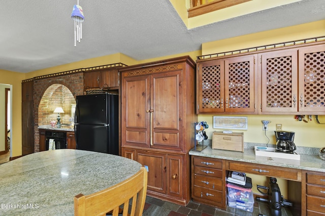 131 Wilshire Dr, Cheshire, MA 01225 - kitchen featuring brown cabinets, a textured ceiling, freestanding refrigerator, and light stone counters