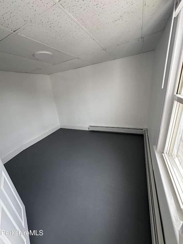 spare room with a drop ceiling and a baseboard radiator