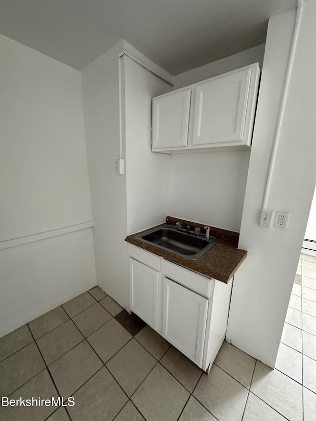 kitchen featuring white cabinetry, sink, and light tile patterned floors