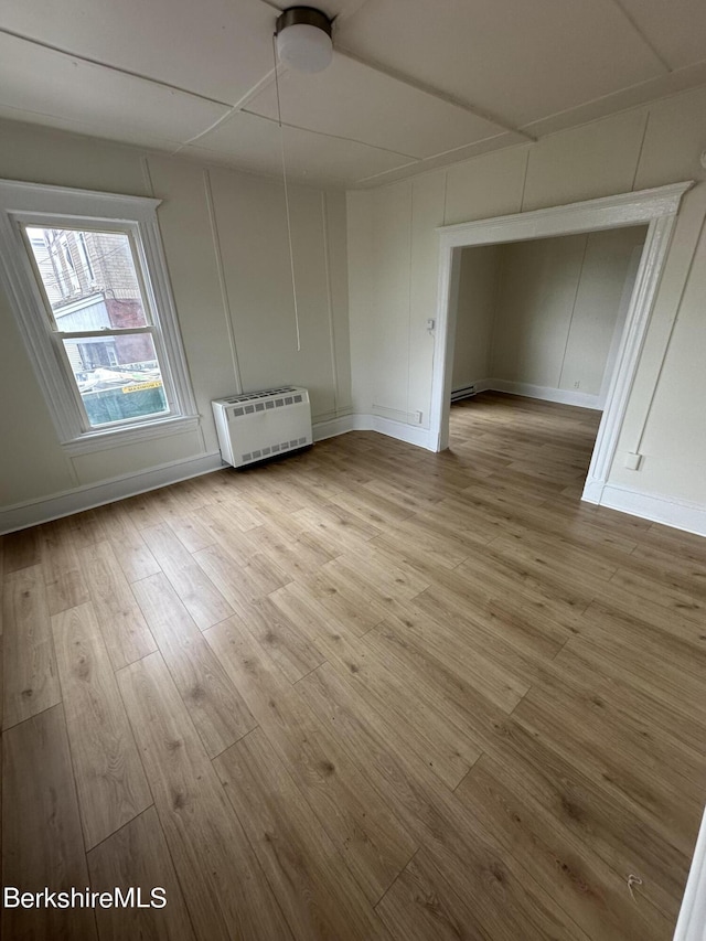 unfurnished room with light wood-type flooring and heating unit