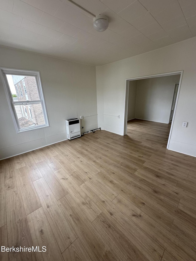 spare room featuring light hardwood / wood-style floors and heating unit