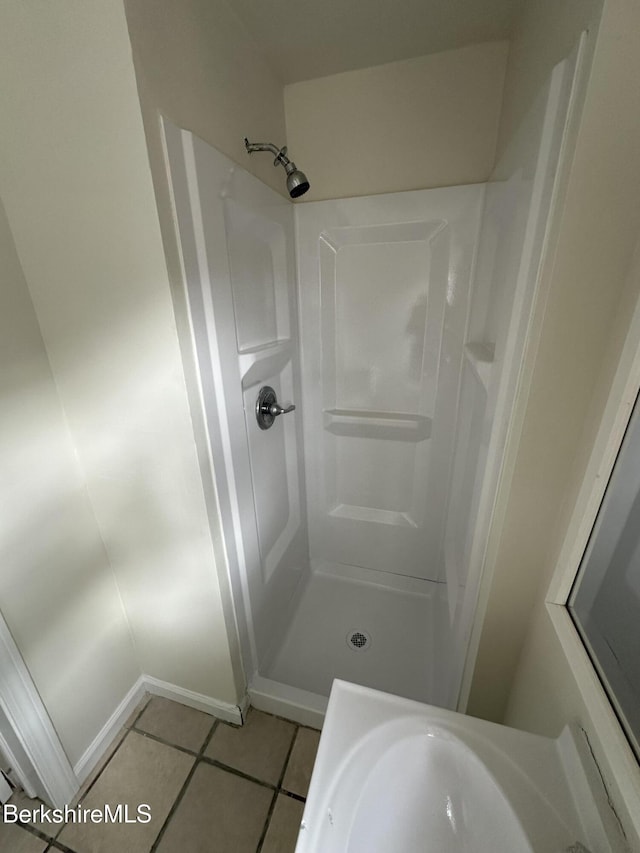 bathroom with tile patterned flooring and walk in shower