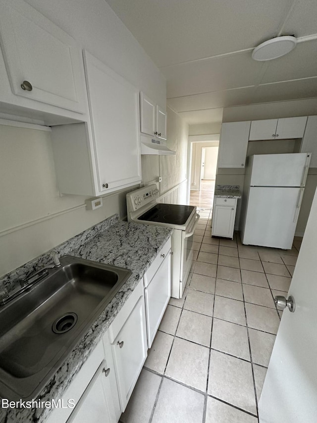 kitchen with sink, electric stove, white refrigerator, white cabinets, and light tile patterned flooring