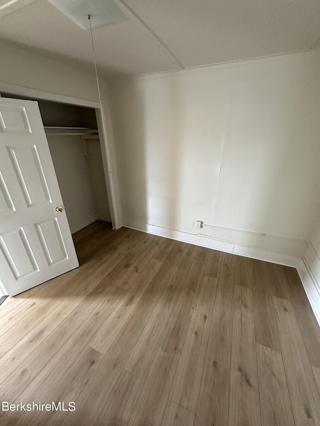 unfurnished bedroom featuring a closet and light hardwood / wood-style floors