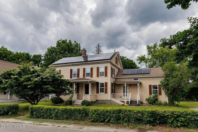 view of front of house with solar panels and a porch