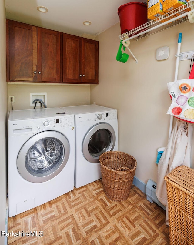 washroom featuring cabinets, light parquet flooring, and washing machine and clothes dryer