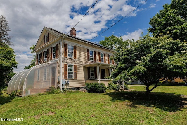 exterior space featuring covered porch and a yard