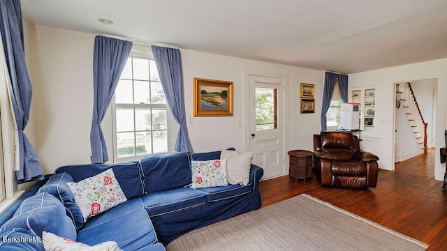 living room with plenty of natural light and dark wood-type flooring