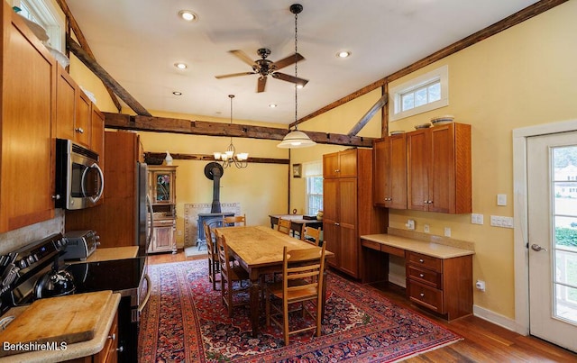 dining room featuring dark hardwood / wood-style floors, a wood stove, and plenty of natural light