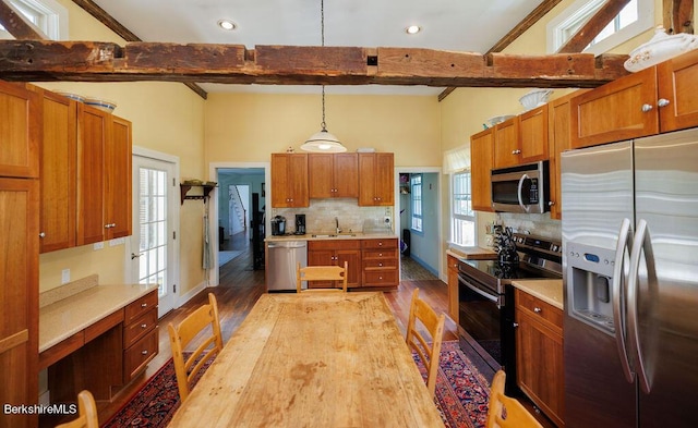 kitchen with beam ceiling, sink, hanging light fixtures, light hardwood / wood-style flooring, and appliances with stainless steel finishes