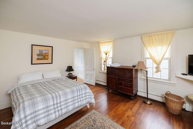 bedroom with hardwood / wood-style floors and baseboard heating